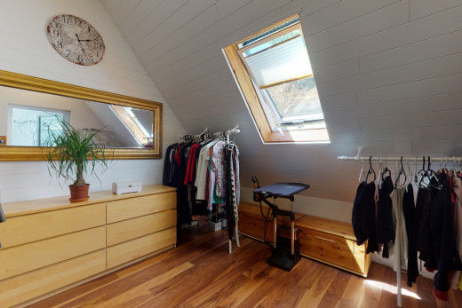 wardrobe featuring skylight, natural light, and hardwood flooring
