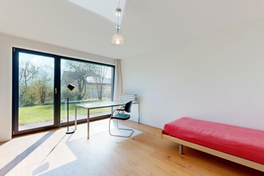 chambre avec cloison sèche, drywall, sol en finition bois, wood finish floor, et lumière naturelle