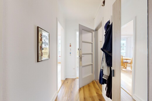 halle / korridor mit wood finish floor, holzfußboden, inside property, natural light, und natürliches licht