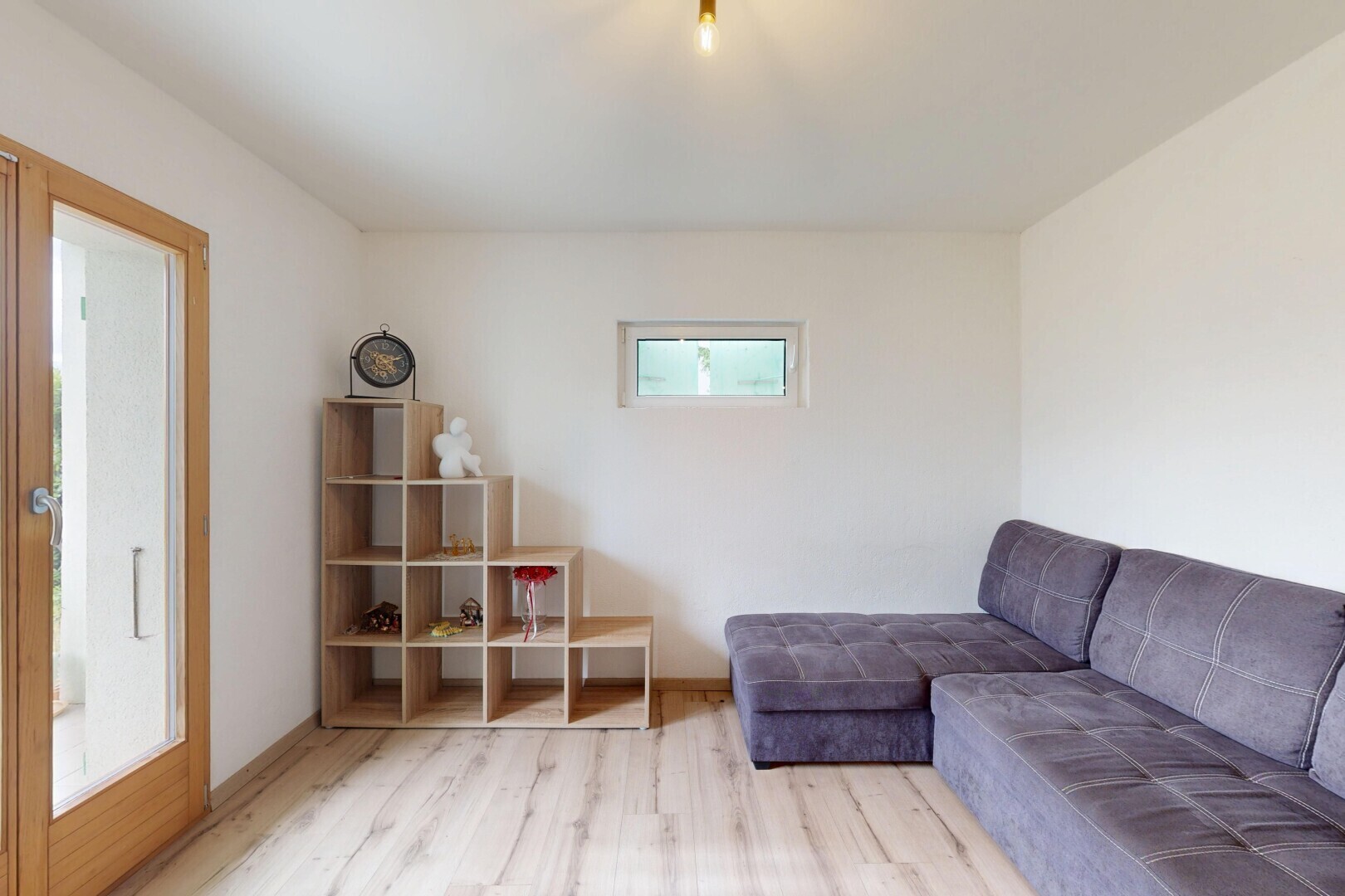 wohnzimmer mit drywall, gipskartonwand, natürliches licht, wood finish floor, und holzfußboden