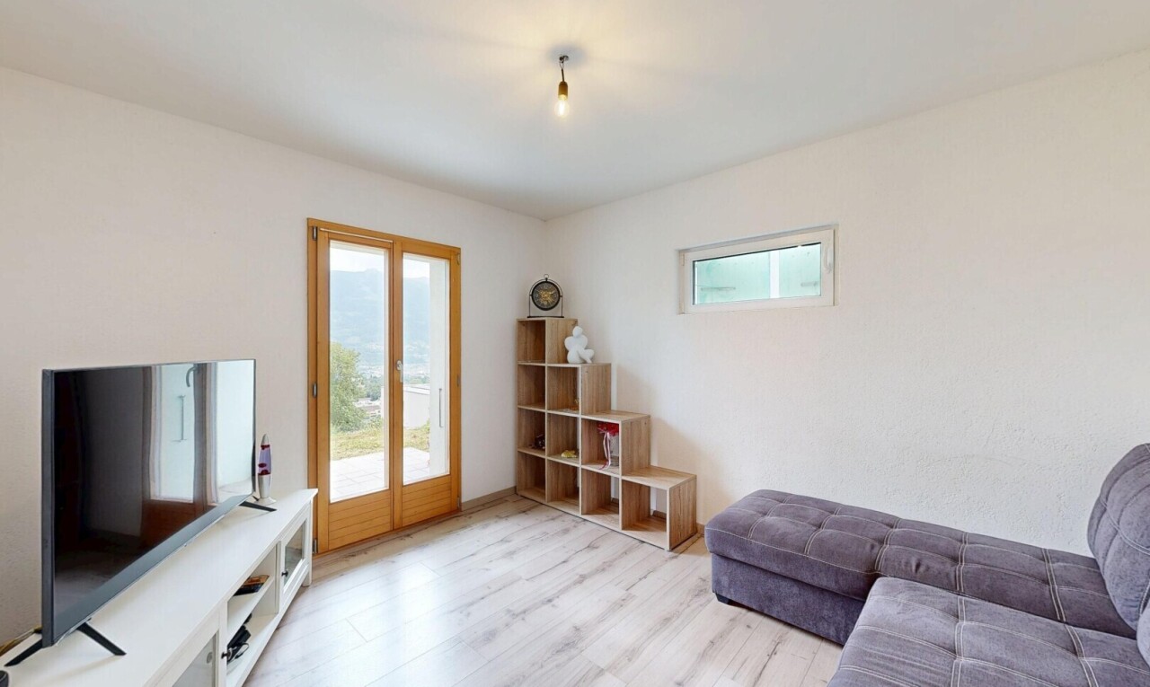 wohnzimmer mit fernseher, natürliches licht, wood finish floor, holzfußboden, und drywall