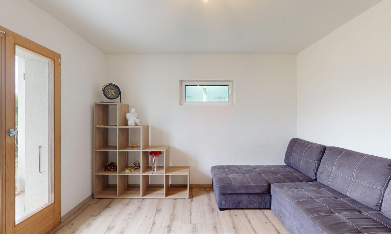 wohnzimmer mit drywall, gipskartonwand, natürliches licht, wood finish floor, und holzfußboden