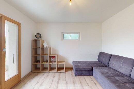 wohnzimmer mit drywall, gipskartonwand, natürliches licht, wood finish floor, und holzfußboden