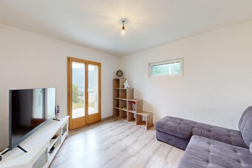 wohnzimmer mit fernseher, natürliches licht, wood finish floor, holzfußboden, und drywall