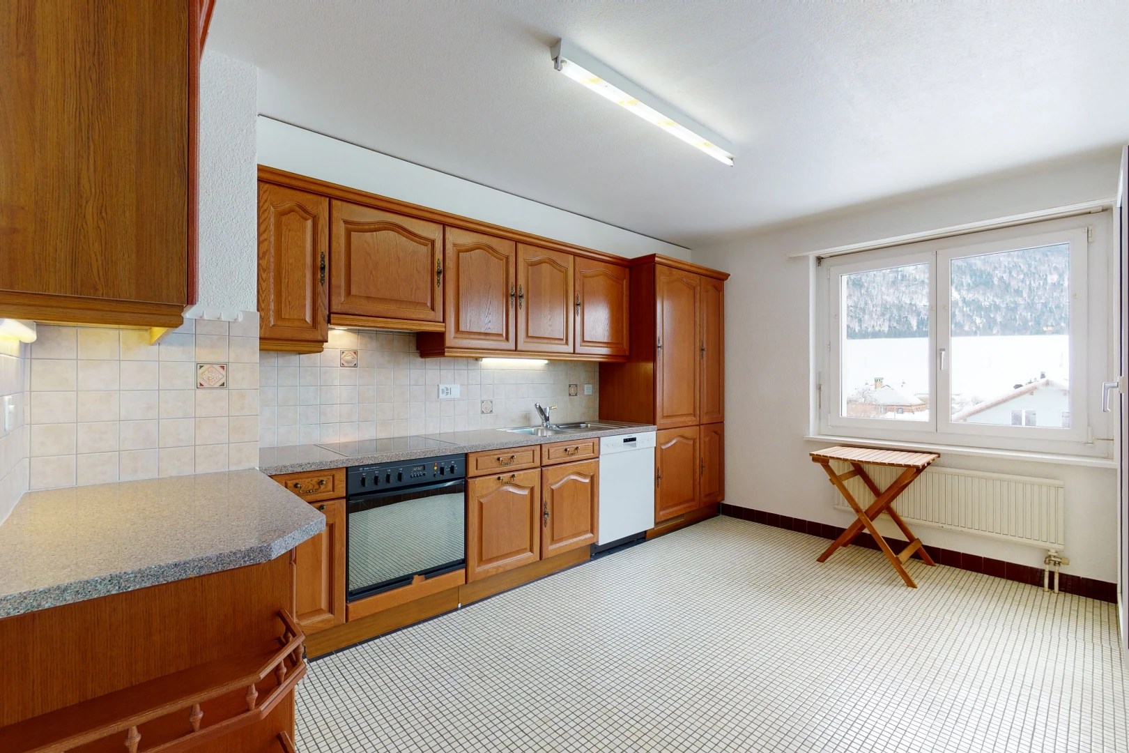 kitchen with natural light, radiator, dishwasher, oven, light countertops, light flooring, and brown cabinets