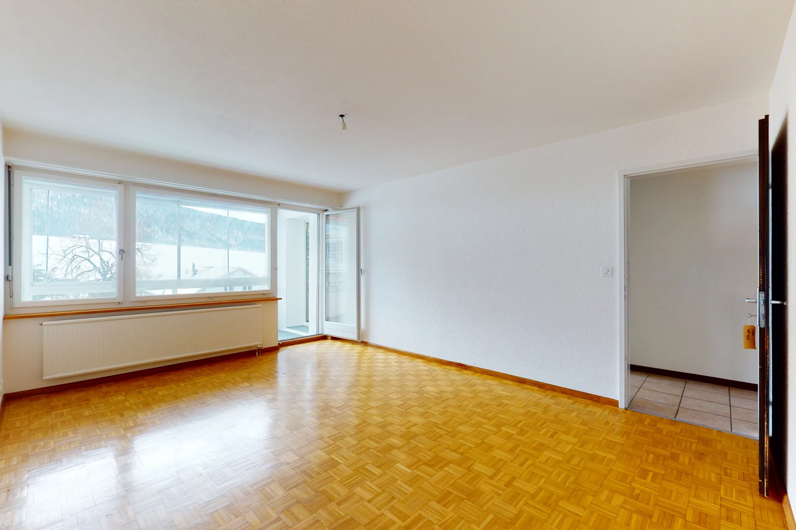 empty room with natural light, tile floors, and radiator