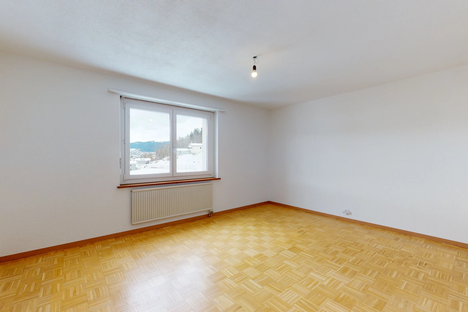 empty room with wood-type flooring, natural light, and radiator