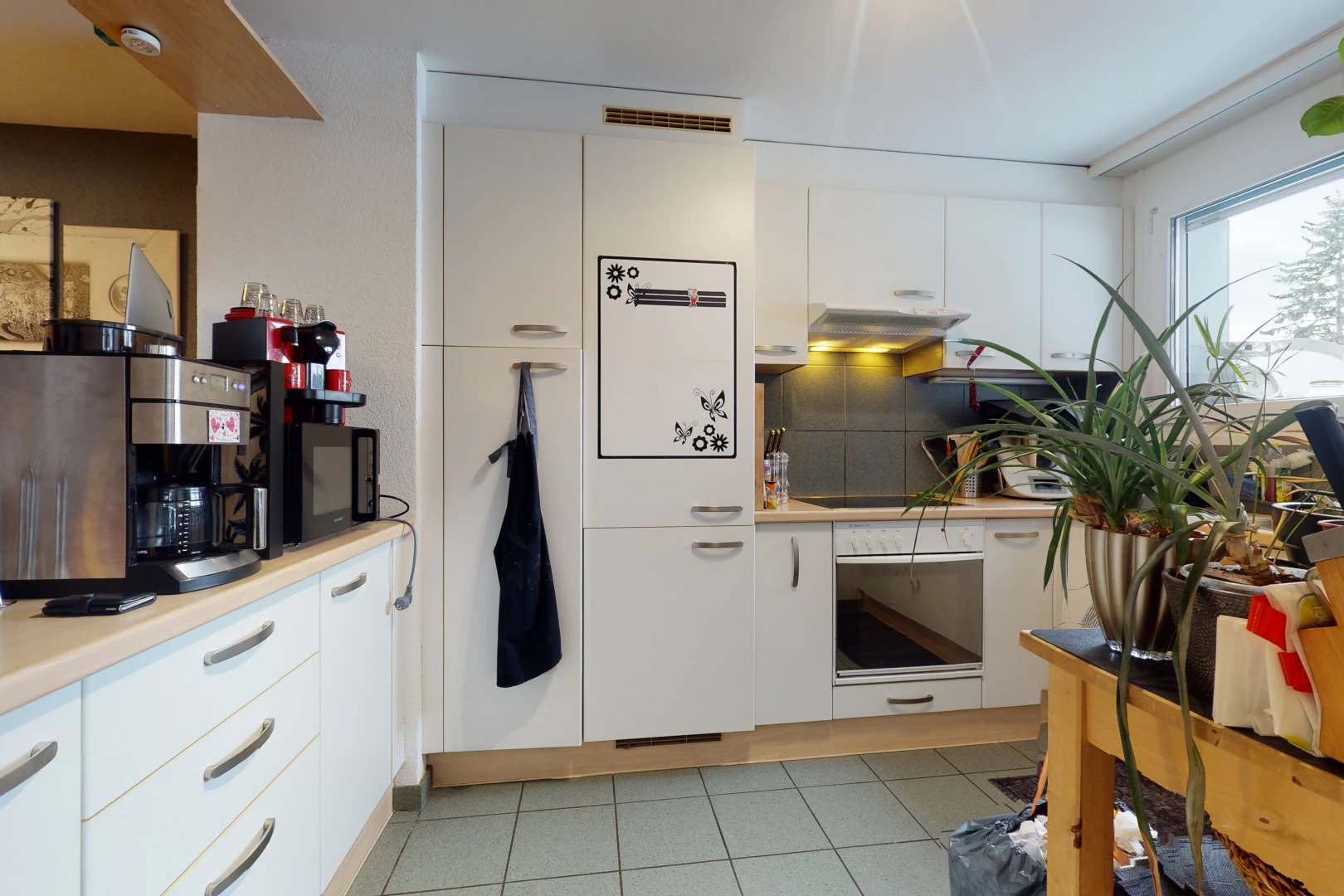 kitchen featuring light tile floors and white cabinets