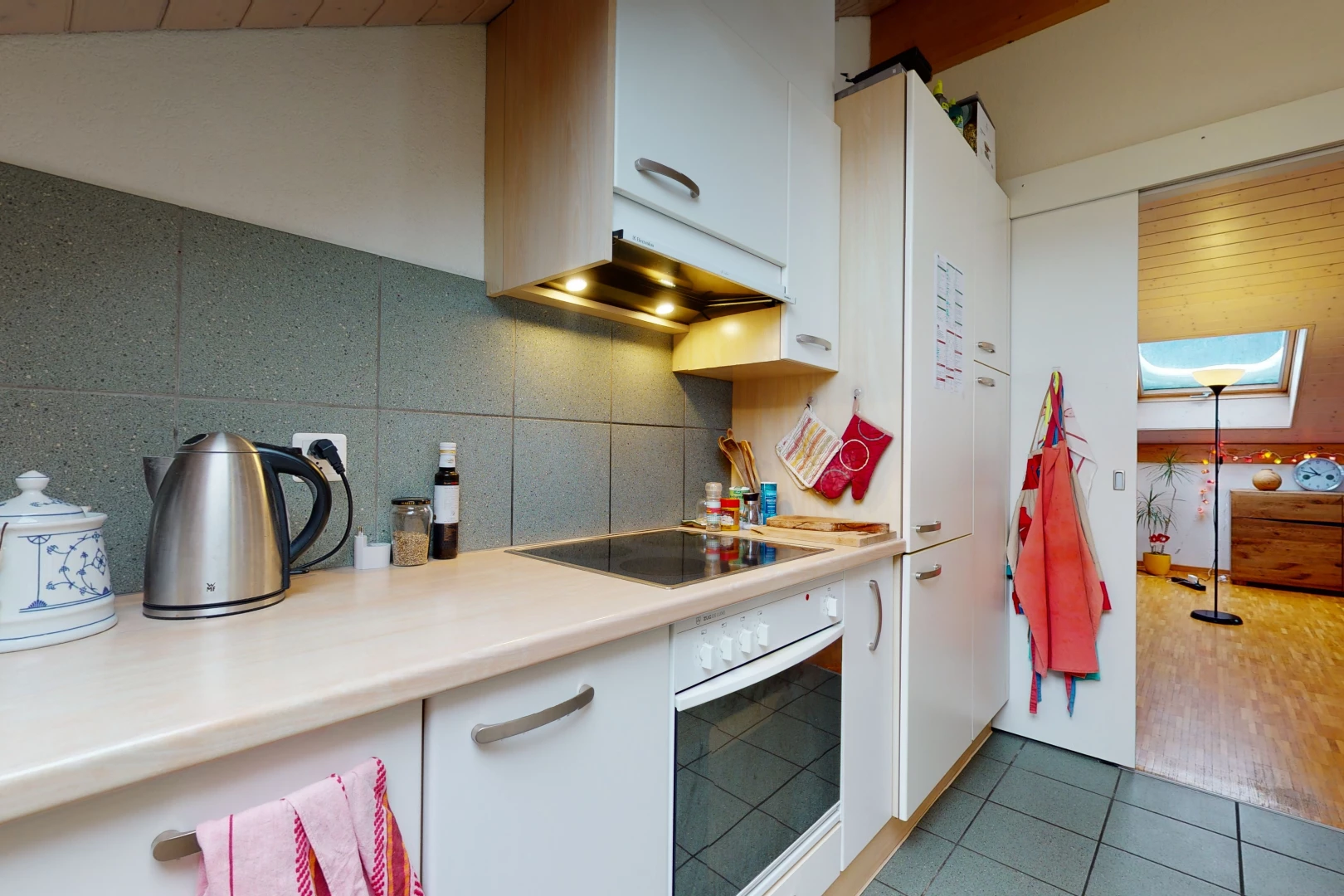 kitchen with oven, electric cooktop, light tile floors, and light countertops