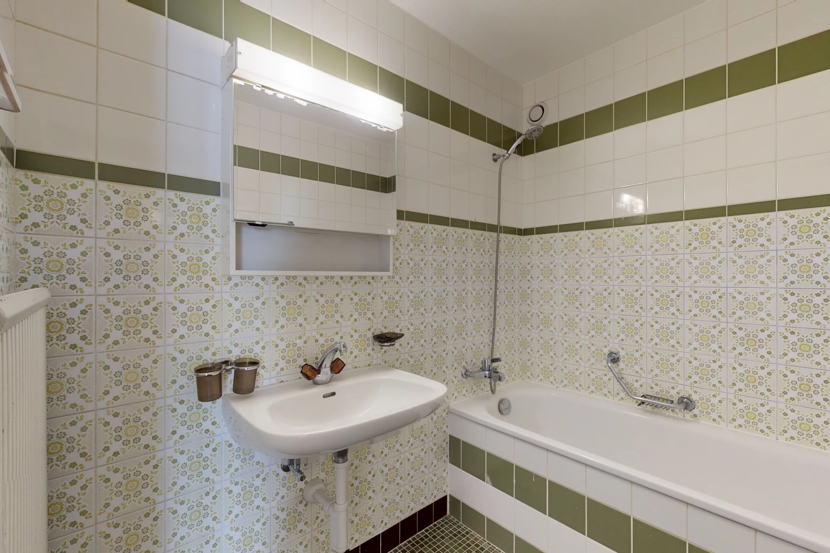 bathroom with radiator, sink, shower / tub combination, and mirror