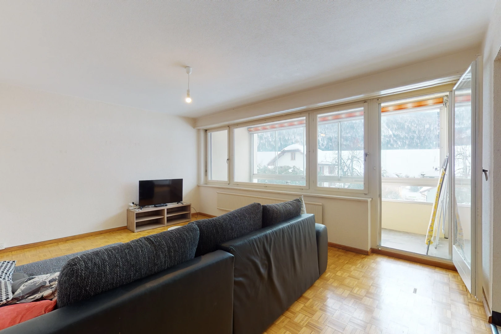 hardwood floored living room featuring natural light and TV