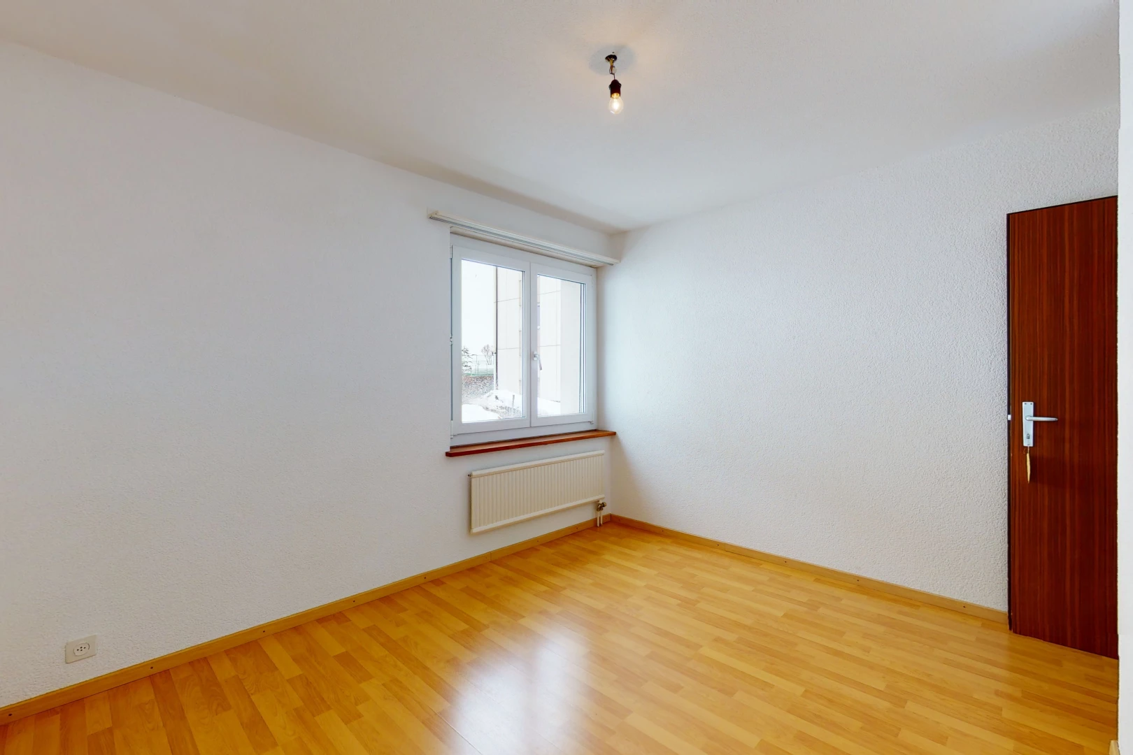 spare room with hardwood floors, natural light, and radiator