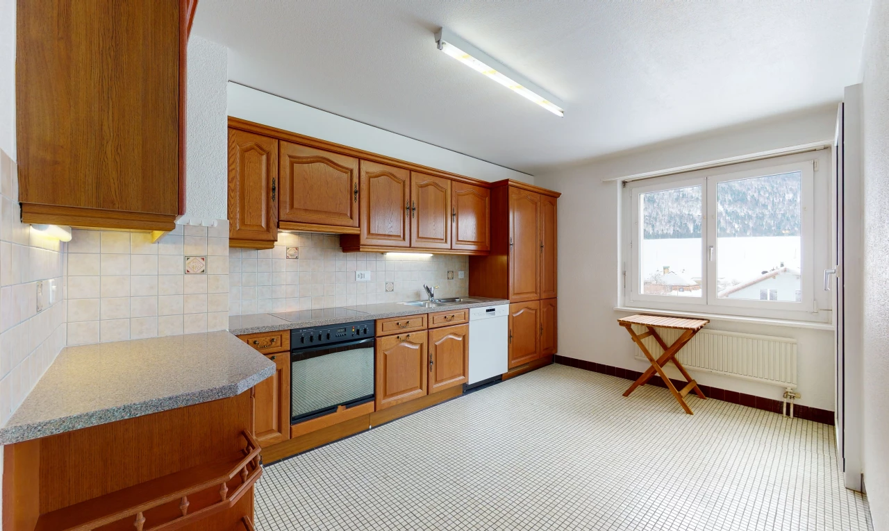 kitchen with natural light, radiator, dishwasher, oven, light countertops, light flooring, and brown cabinets