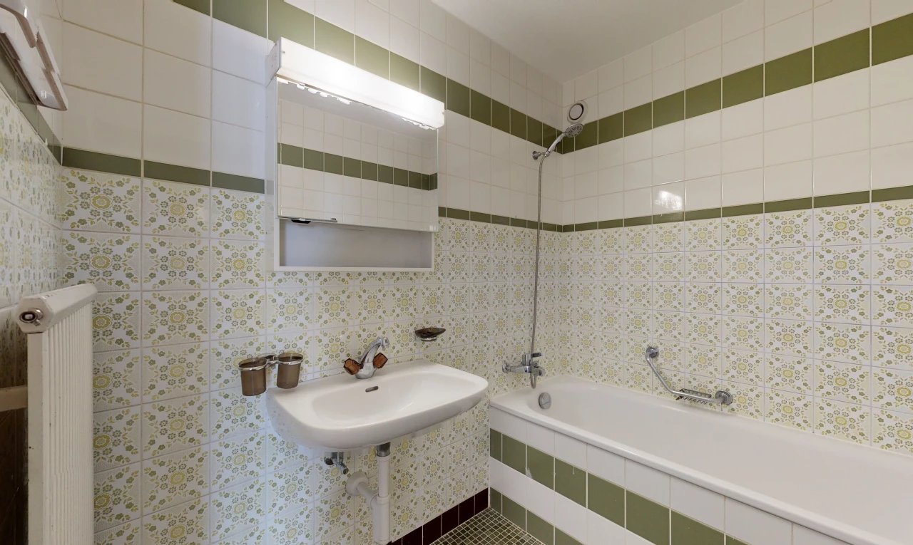 bathroom with radiator, sink, shower / tub combination, and mirror