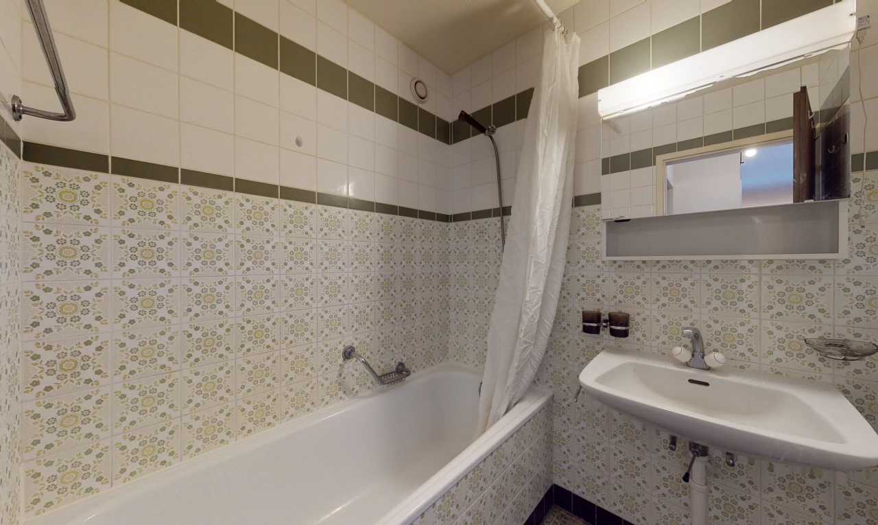 bathroom with shower curtain, mirror, sink, and bathing tub / shower combination