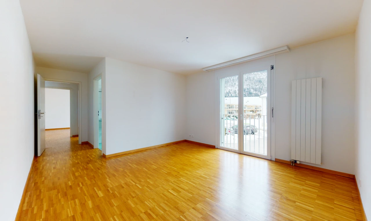 hardwood floored spare room with natural light and radiator