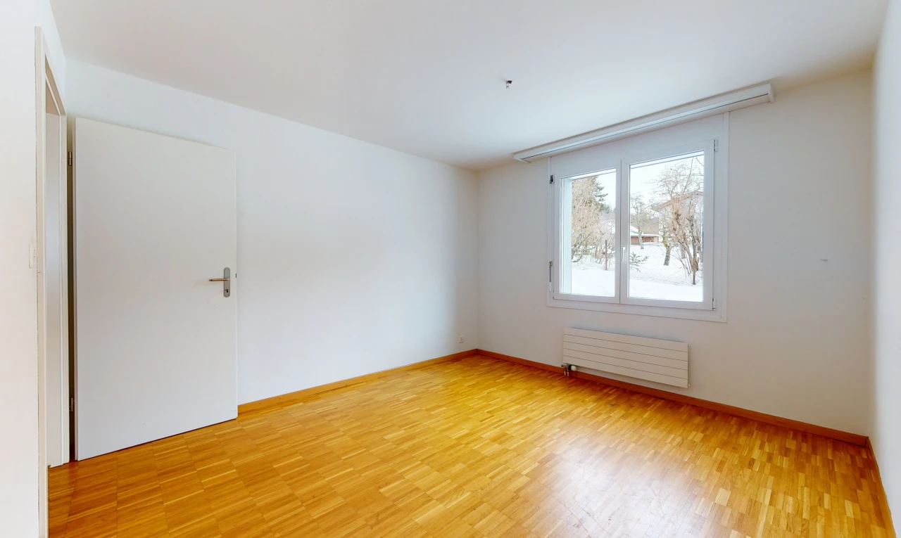 wood floored spare room with natural light and radiator