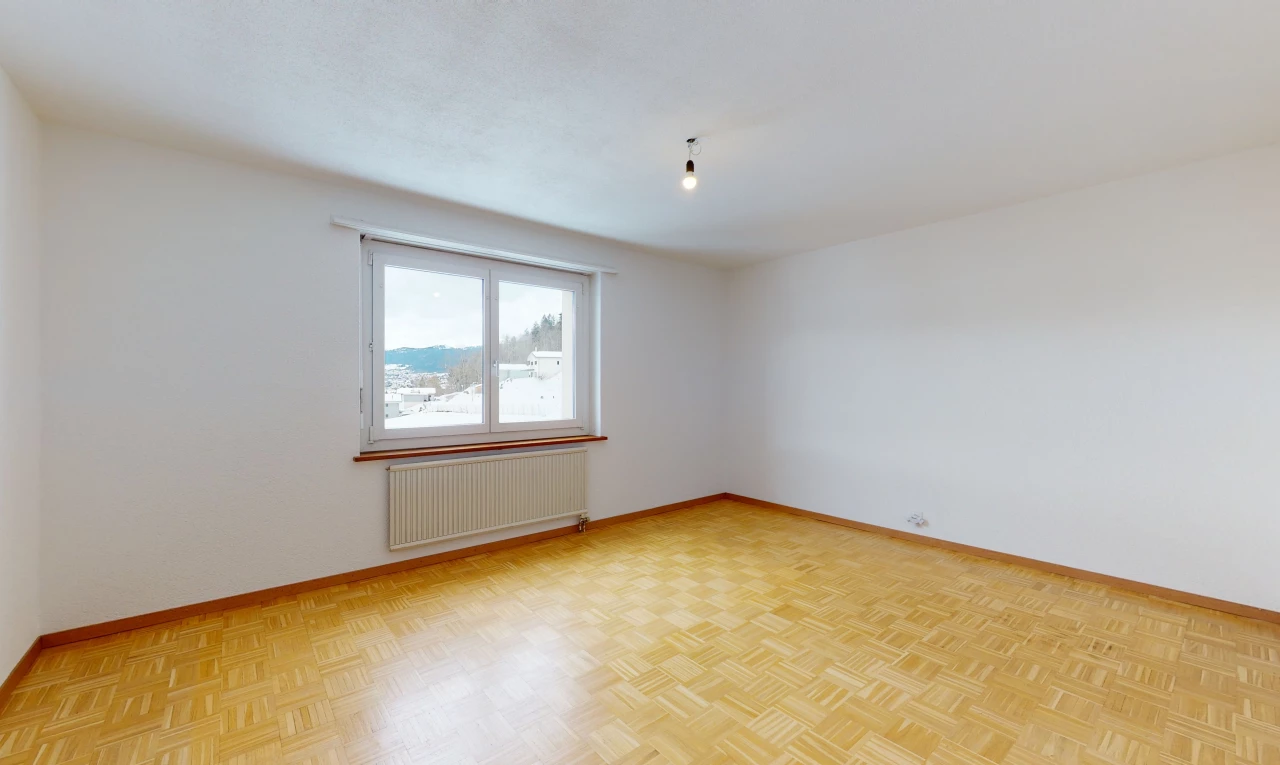 empty room with wood-type flooring, natural light, and radiator