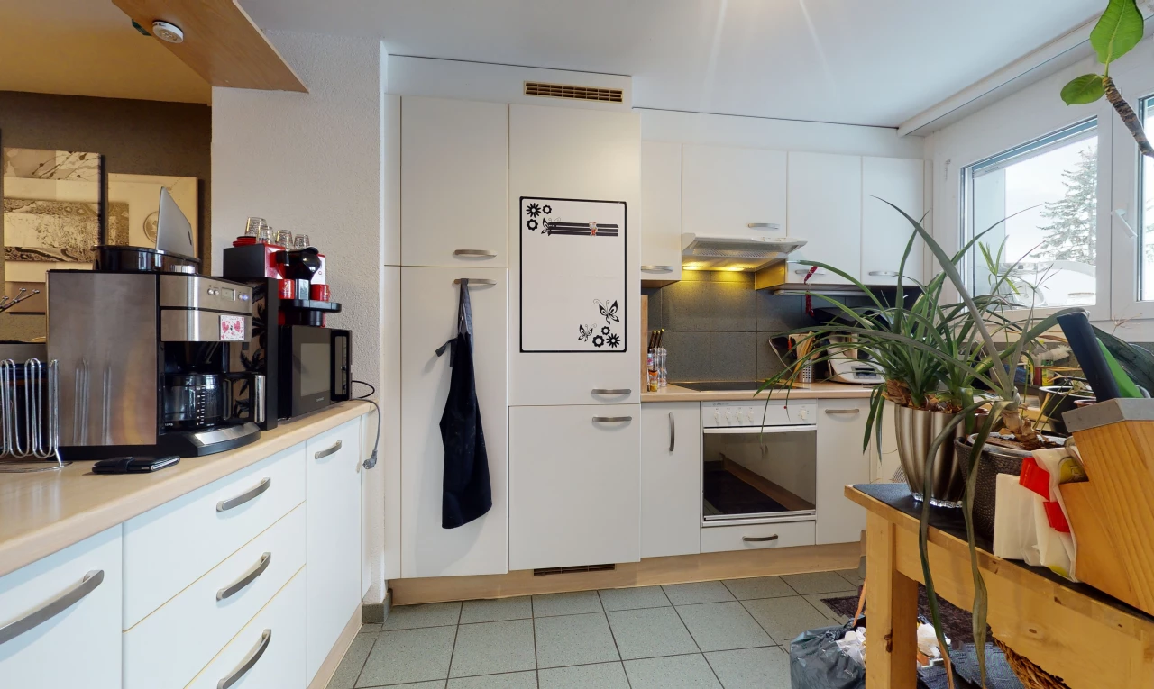 kitchen featuring light tile floors and white cabinets