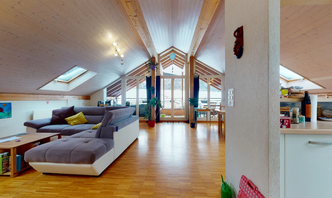 living room with wood-type flooring, vaulted ceiling with skylight, and plenty of natural light