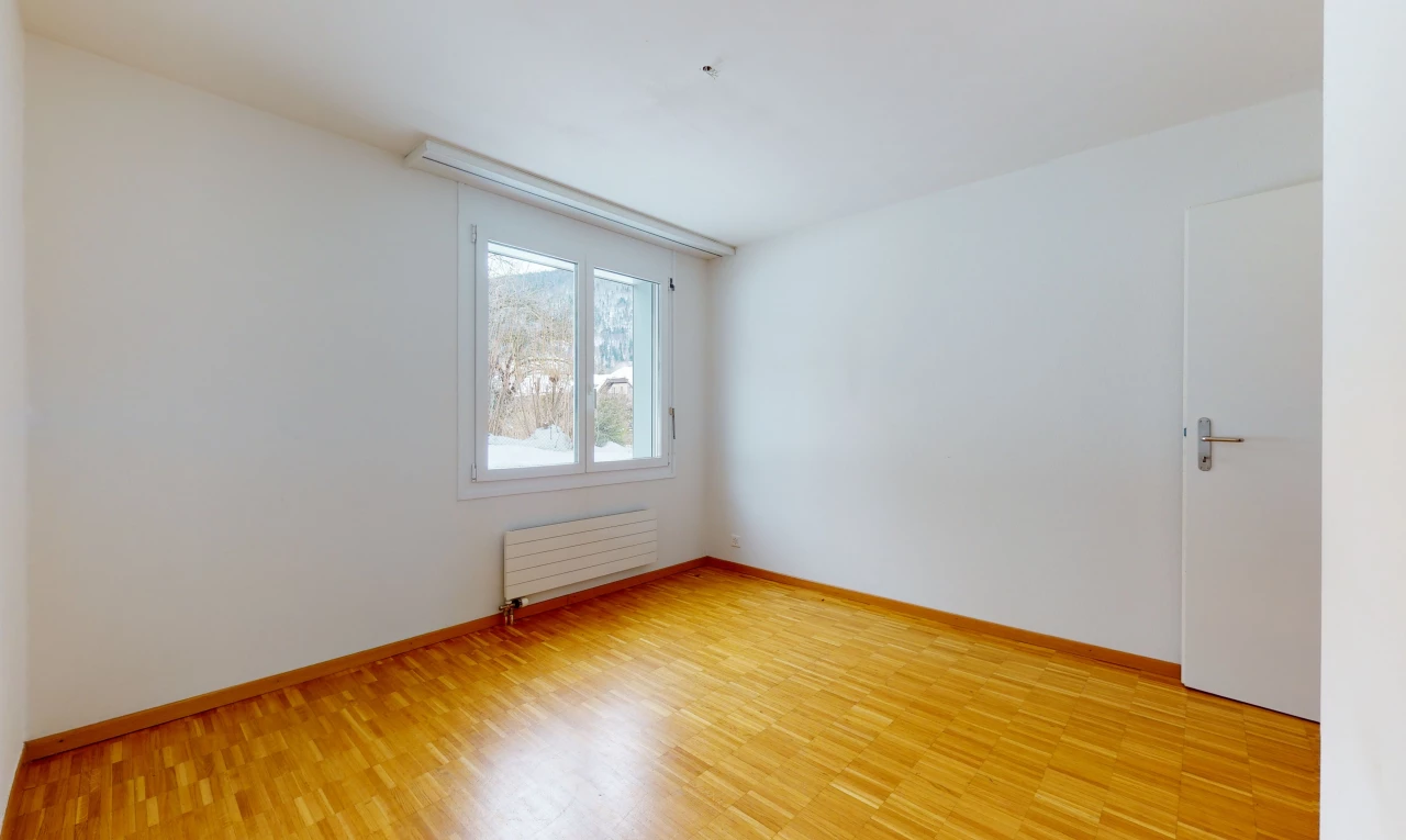 spare room with natural light, hardwood flooring, and radiator