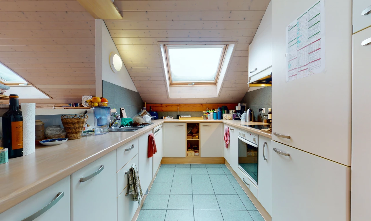 kitchen featuring skylight, oven, electric cooktop, light tile flooring, white cabinets, and light countertops
