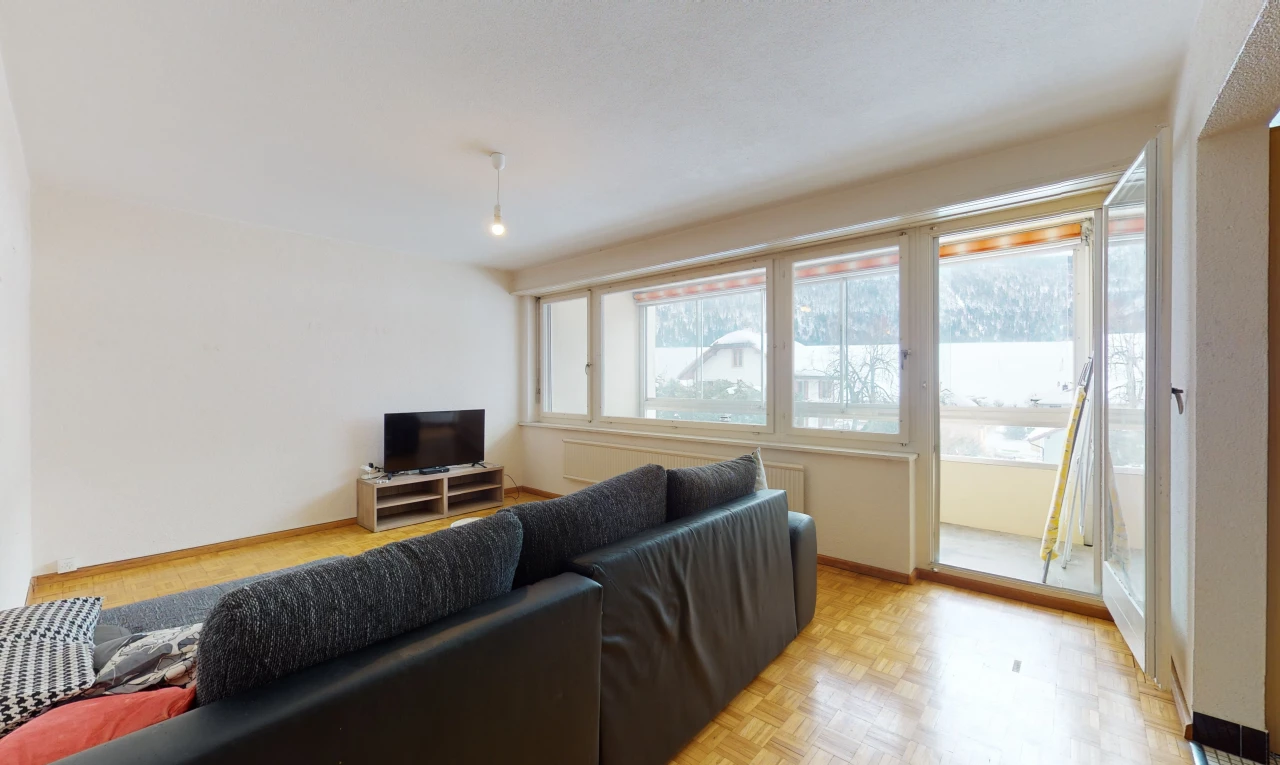 hardwood floored living room featuring natural light and TV