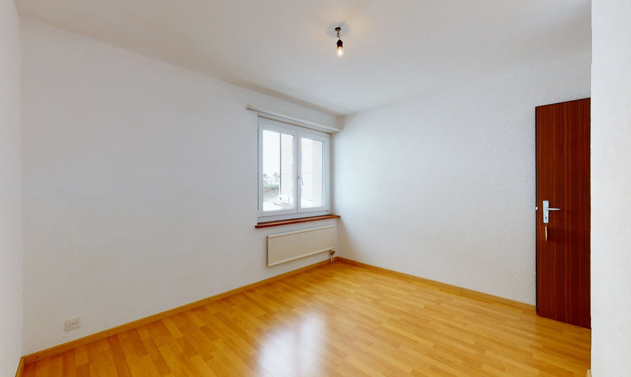 spare room with hardwood floors, natural light, and radiator