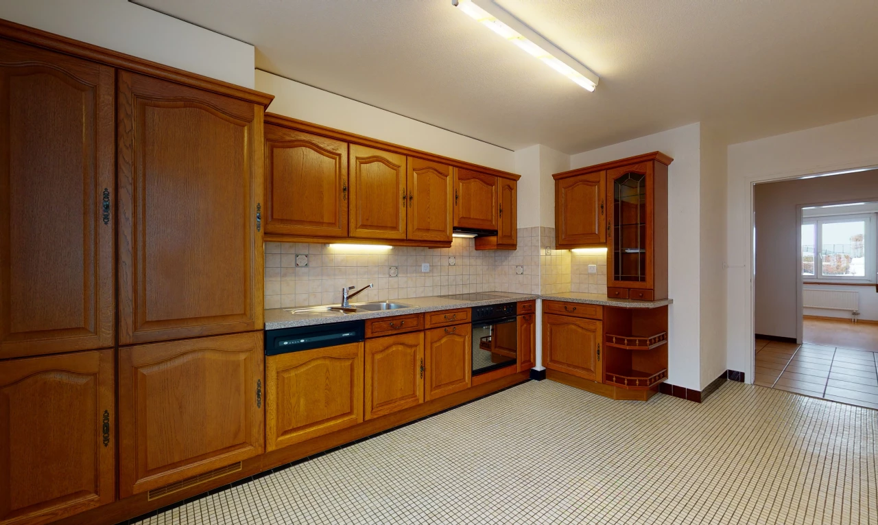 kitchen with oven, brown cabinetry, light countertops, and light tile floors