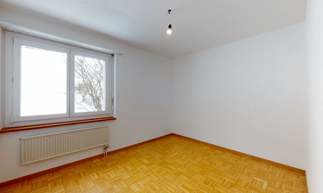 wood floored spare room with natural light and radiator