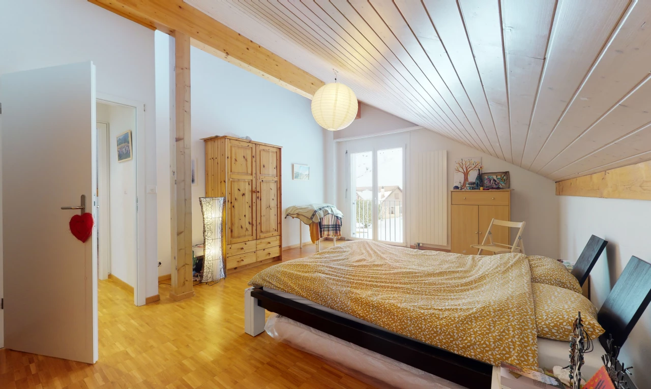 hardwood floored bedroom with natural light and vaulted ceiling