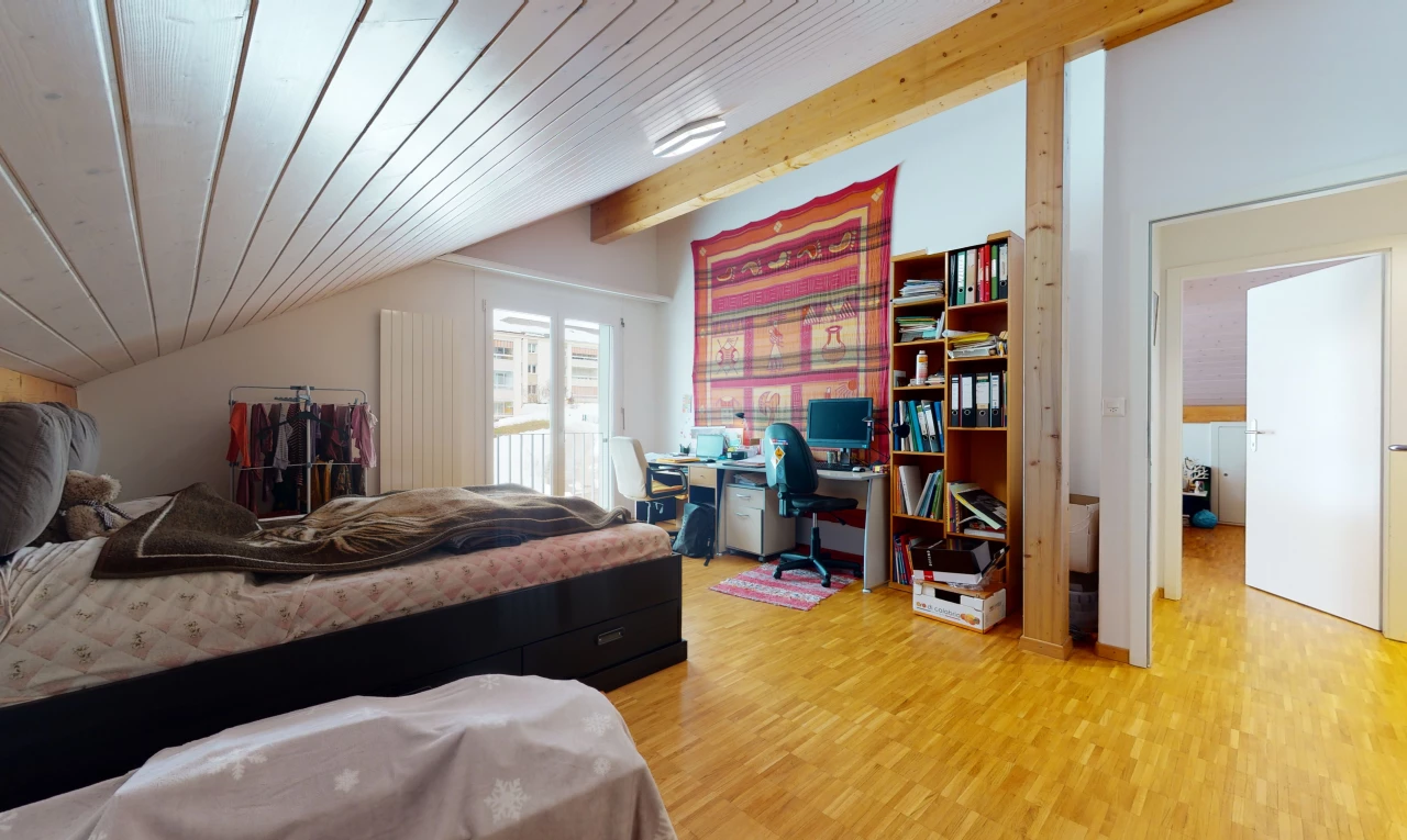hardwood floored bedroom with lofted ceiling with beams and natural light