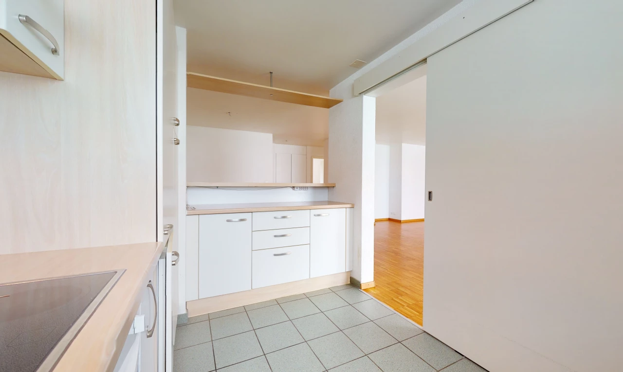 kitchen featuring electric stovetop, white cabinets, light countertops, and light hardwood flooring