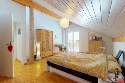 hardwood floored bedroom with natural light and vaulted ceiling