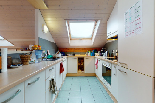 cuisine avec carrelage, lucarne, four, cuisinière électrique, comptoirs claires, sol clair, et armoires blanches