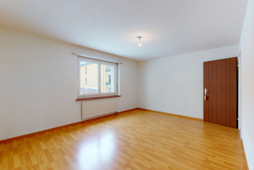 chambre vide avec parquet, lumière naturelle, et radiateur