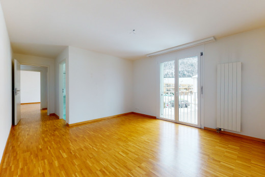chambre vide avec lumière naturelle, parquet, et radiateur