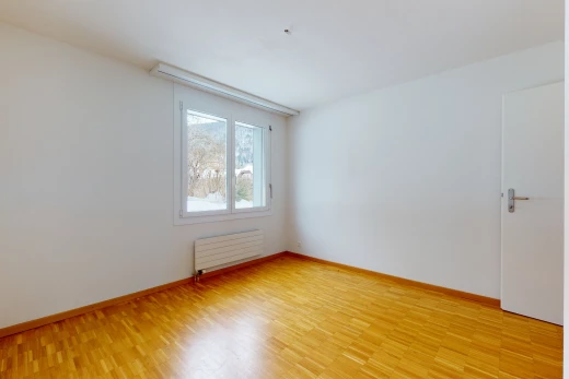 spare room with natural light, hardwood flooring, and radiator