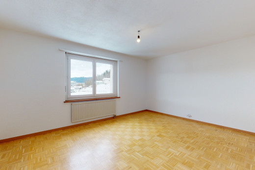 chambre vide avec parquet, lumière naturelle, et radiateur