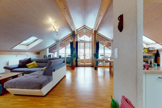 living room with wood-type flooring, vaulted ceiling with skylight, and plenty of natural light