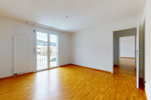 chambre vide avec parquet, lumière naturelle, et radiateur