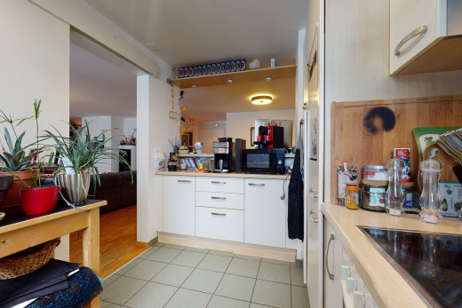 cuisine avec carrelage, parquet, cuisinière électrique, micro-onde, armoires blanches, et sol clair