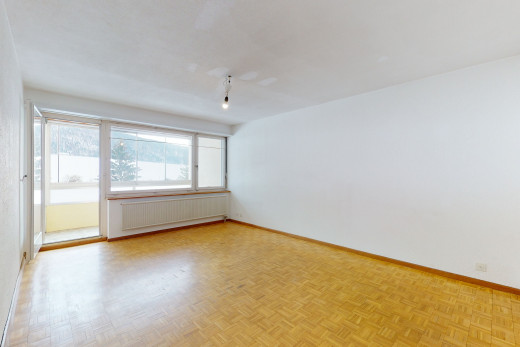 chambre vide avec parquet, lumière naturelle, et radiateur