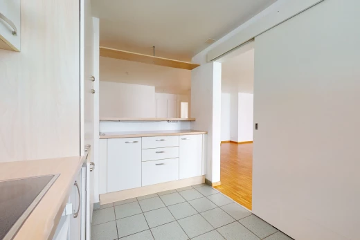 kitchen featuring electric stovetop, white cabinets, light countertops, and light hardwood flooring