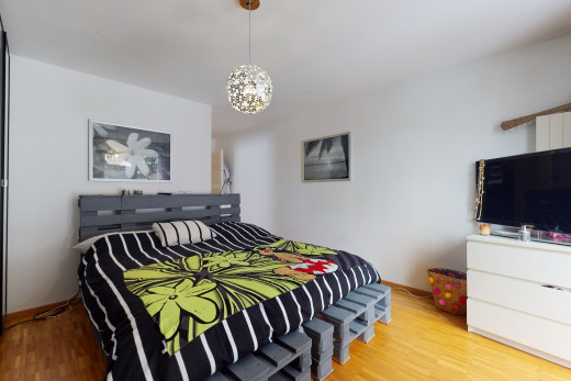 chambre à coucher avec parquet et télévision