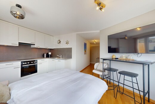 cuisine avec wood finish floor, sol en finition bois, four, backsplash, et dosseret