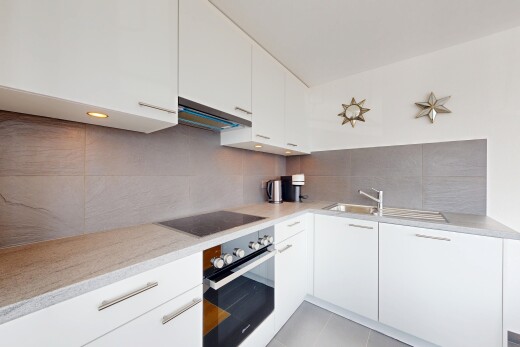 cuisine avec four, armoires blanches, armoires à panneau plat, dosseret, et backsplash