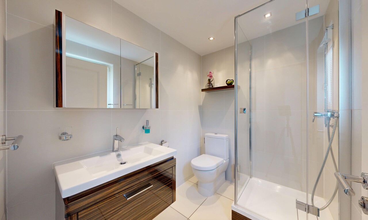 salle de bains avec douche, salle de bain complète, lavabo (ou coiffeuse selon le contexte), toilette, et inside property