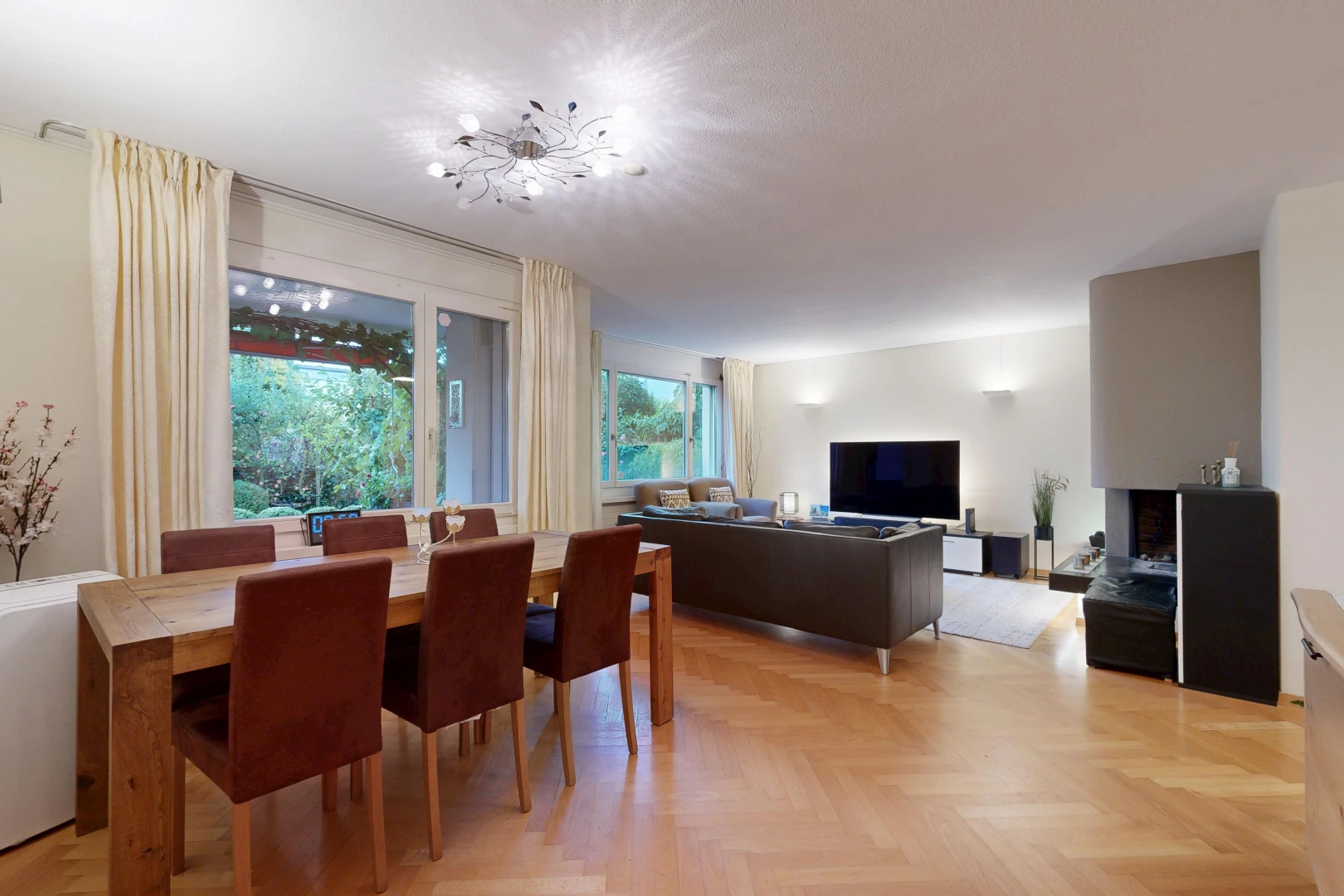 wohn- / esszimmer mit drywall, gipskartonwand, wood finish floor, holzfußboden, und fernseher