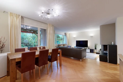 wohn- / esszimmer mit drywall, gipskartonwand, wood finish floor, holzfußboden, und fernseher